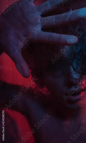 Portrait of man in shower with red and blue lights