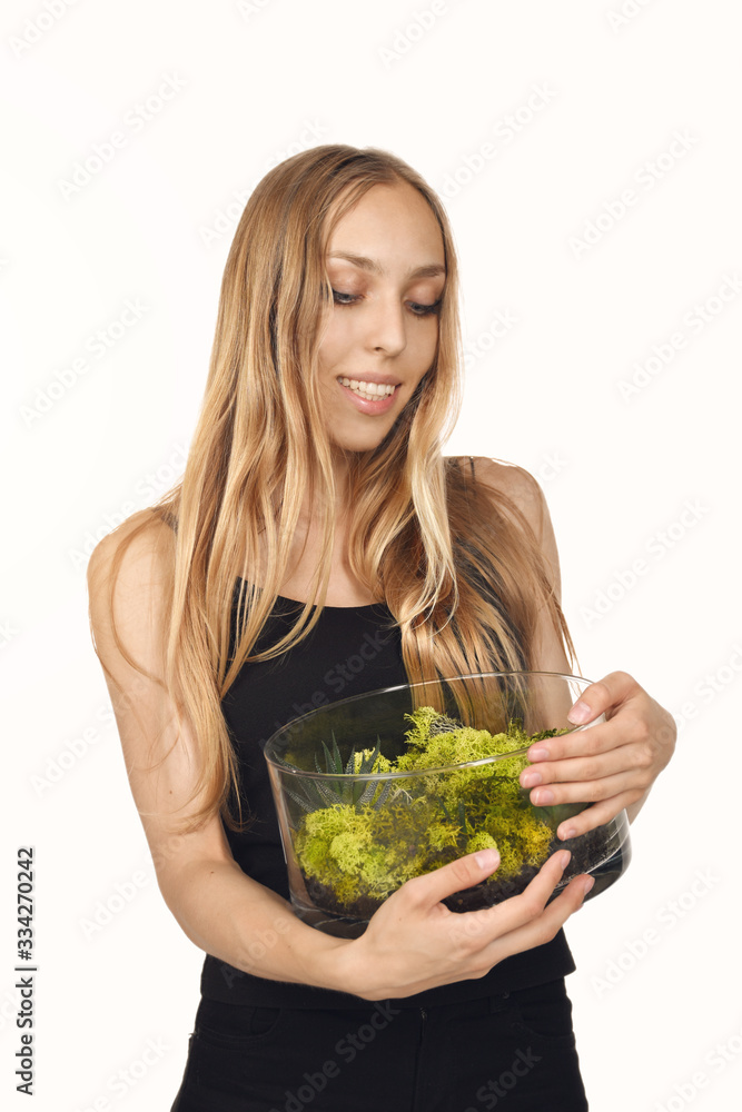 Beautiful blond happy young woman in black, smiling and holding a glass terrarium or florarium, isolated on white background Beautiful blond happy young woman in black, smiling and holding a glass terrarium or florarium, isolated on white background