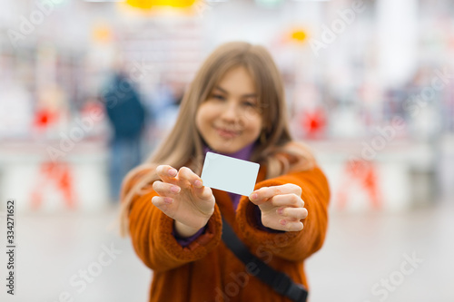 Young woman holds credit card in hands
