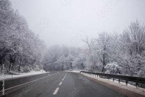 Snow on the road at winter. Trees covered with snow next to the road. Cestobrodica in Serbia.