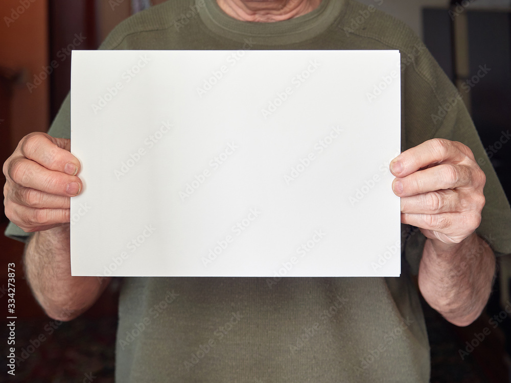 Obraz premium the hands of an old man hold a white sheet without text. coronavirus, covid-19.
