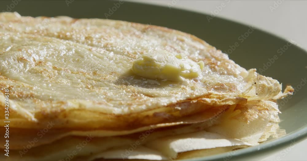 Close up shot of thin pancakes stacked on plate in a pile Close up shot of thin pancakes stacked on plate in a pile