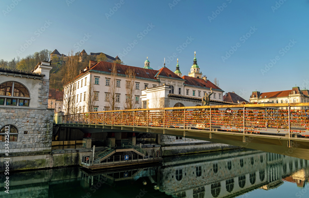 Butcher bridge with love padlocks, Saint Nicholas Cathedral and Ljubljana castle in the background, Ljubljana, Slovenia