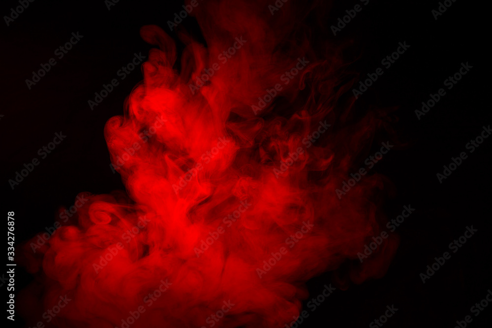 Colorful smoke close-up on a black background. Red cloud of smoke.