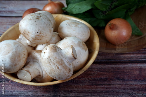 Mushrooms, spinach and onions on a wooden table