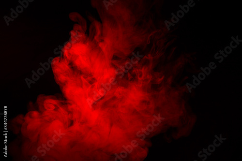 Colorful smoke close-up on a black background. Red cloud of smoke.