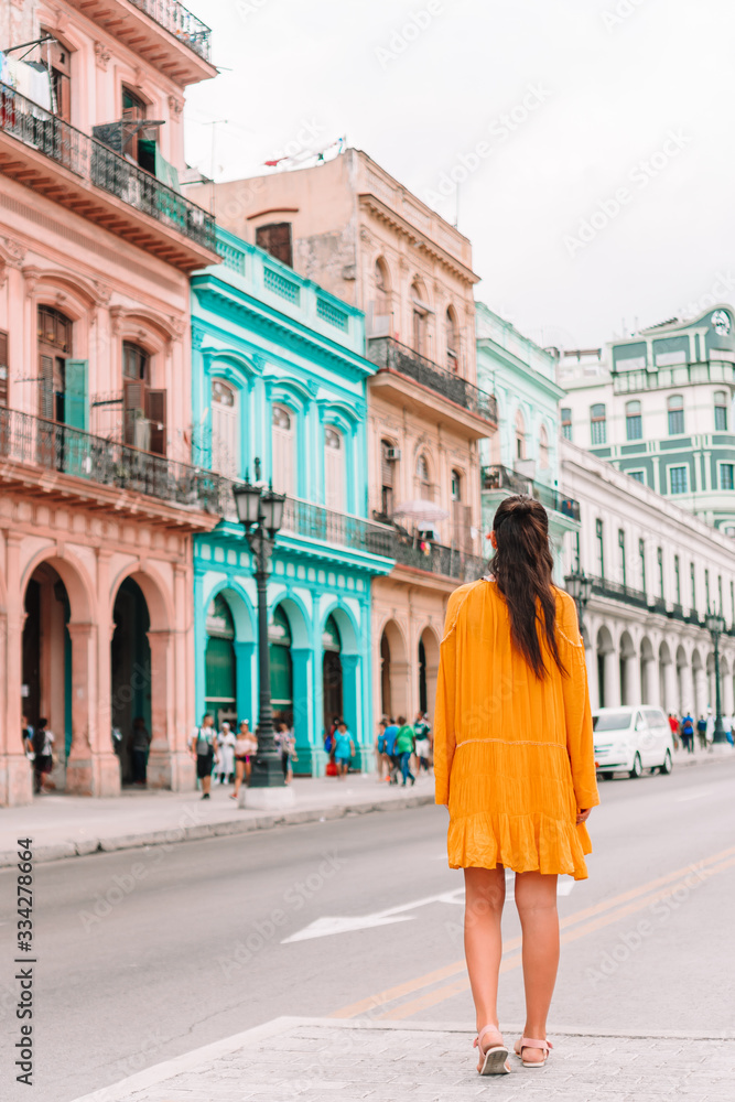 Tourist girl in popular area in Havana, Cuba. Back view of young woman traveler