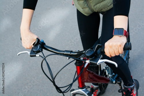 Female hands driving a bicycle on the background of the road. Sport lifestyle