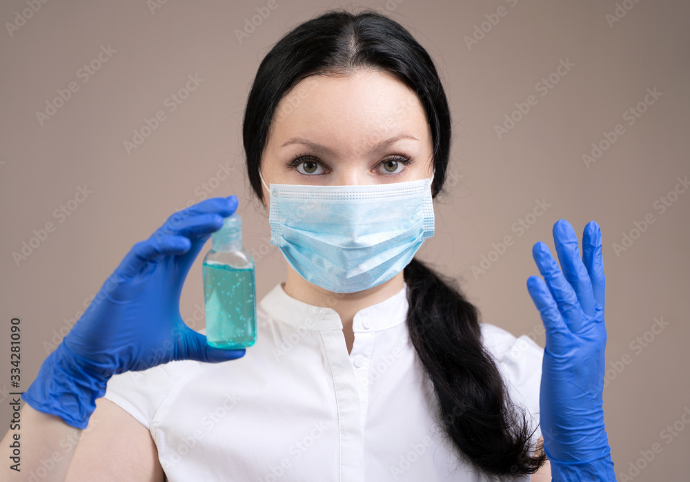 A girl in a medical mask and rubber gloves is holding an alcohol gel, a concept to prevent the spread of the coronavirus. A girl in a medical mask and rubber gloves is holding an alcohol gel, a concept to prevent the spread of the coronavirus.
