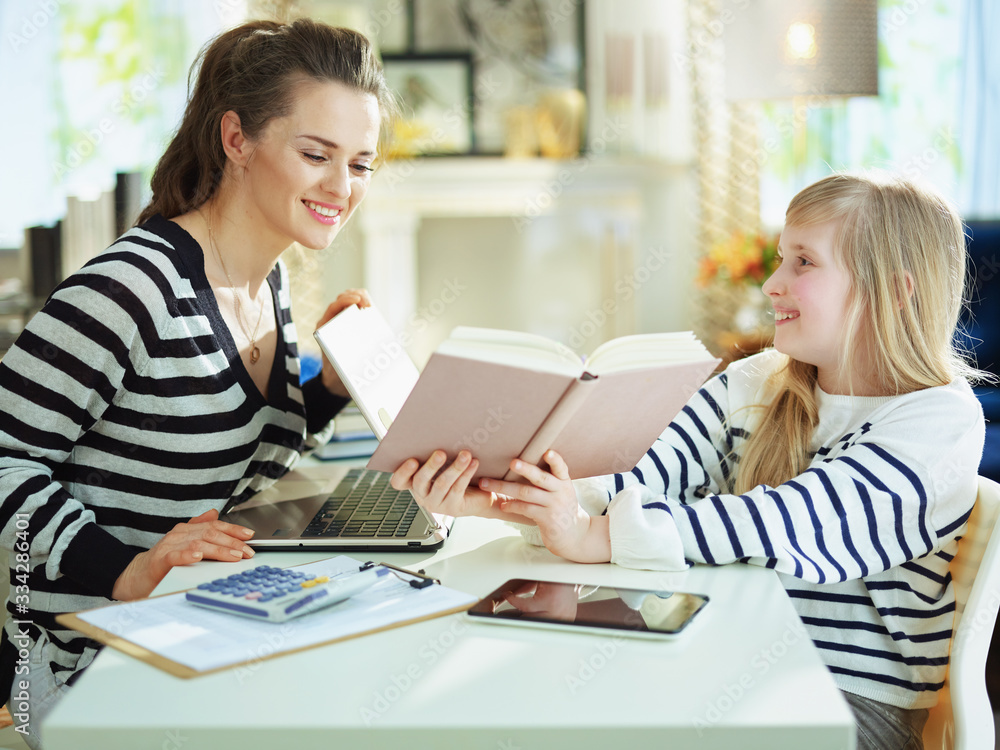 mother at modern home in sunny day working and helping child mother at modern home in sunny day working and helping child