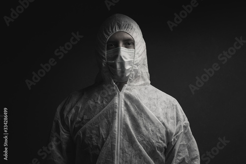 dramatic portrait of physician in protective suit and protective mask