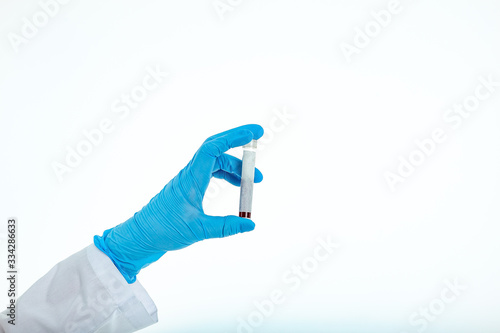 Doctor's hand in a medical glove holds a test tube with a place for inscription. Coronavirus drug search concept. Place for text. Isolated on a white background