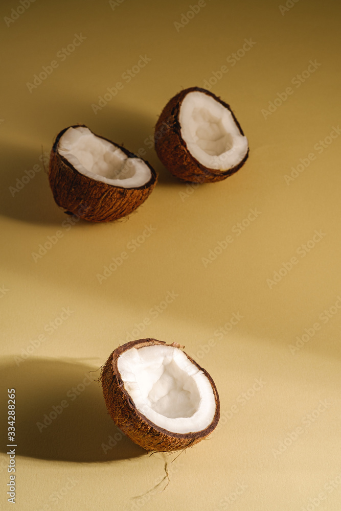 Coconut fruits on cream yellow plain background, abstract food tropical concept, angle view copy space Coconut fruits on cream yellow plain background, abstract food tropical concept, angle view copy space