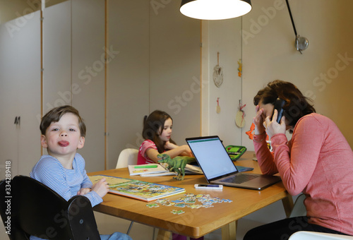 Obraz na plátně Eine Mutter arbeitet im Homeoffice zusammen mit ihren Kindern am 30