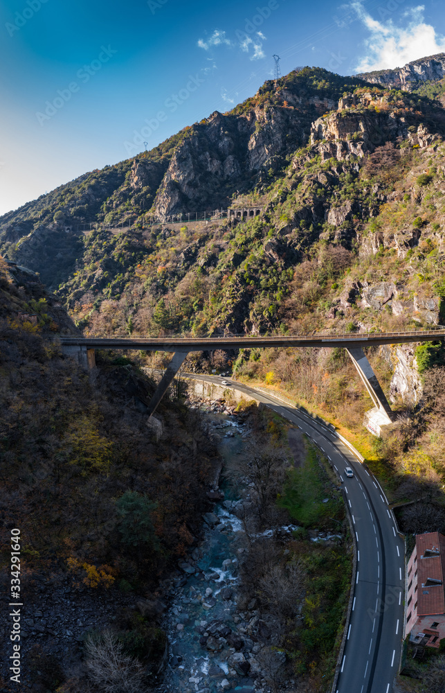 The mountain river along the Road, Aerial panoramic drone view of a scenic highway by the beautiful Landscape covered in clouds and fog, bridge and viaduct, The mountain river along the road,