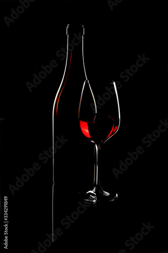 Bicchiere di vino con bottiglia su sfondo nero