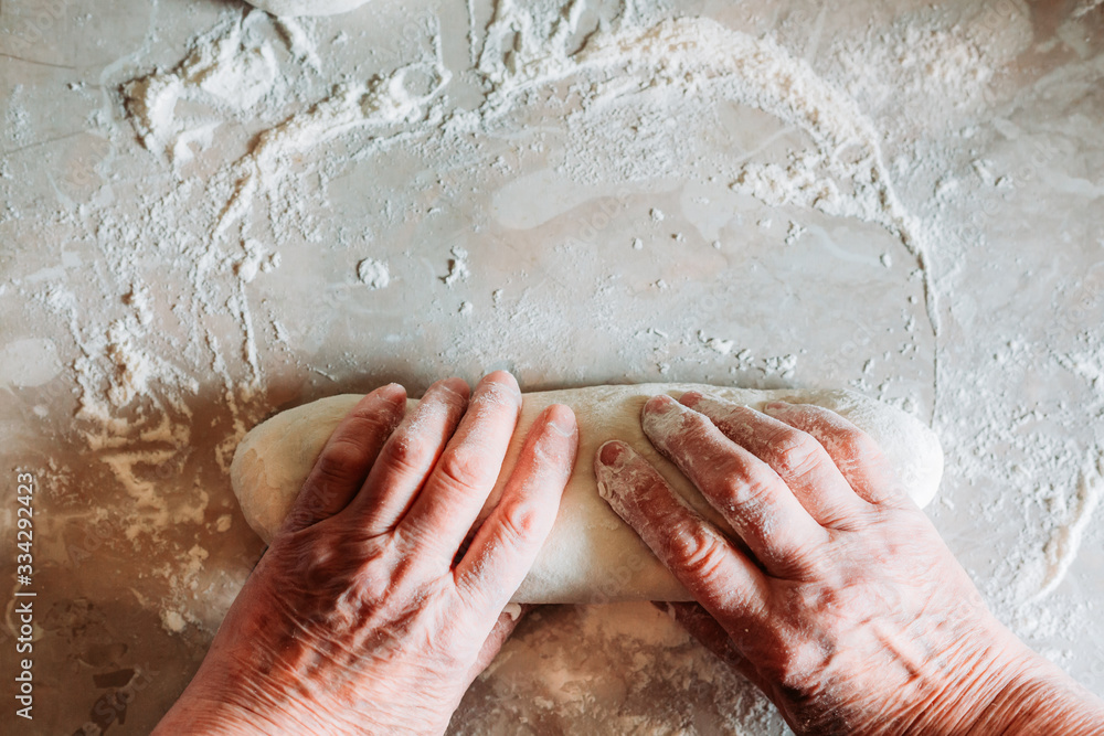 Fototapeta premium Female hands kneading raw homemade bread loafs on the table. Homemade cooking