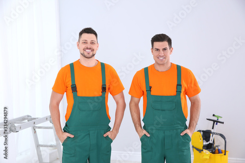 Team of professional janitors in uniform indoors. Cleaning service