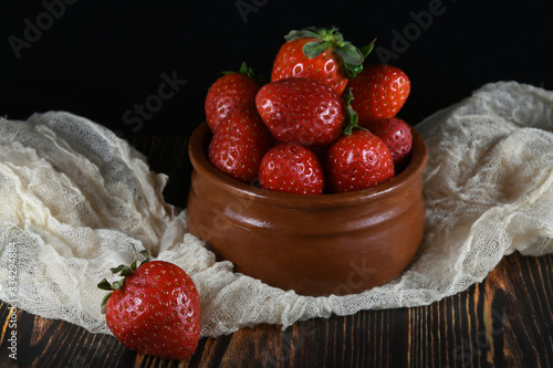 Strawberries in a bowl with a napkin on balck background