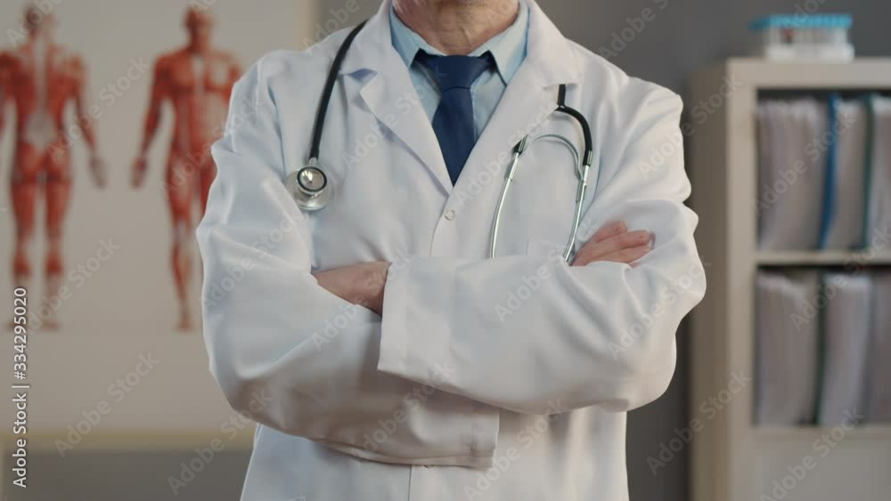 Doctor standing with arms crossed in hospital office. Doctor standing with arms crossed in hospital office.