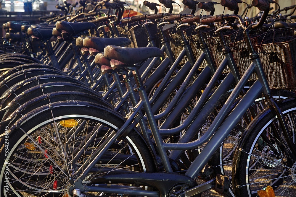 Many bicycles parked on the street for rental Many bicycles parked on the street for rental