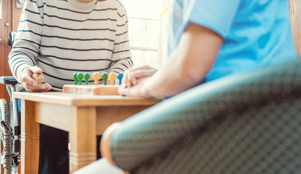 Nurse and senior in retirement home playing a board game Nurse and senior in retirement home playing a board game