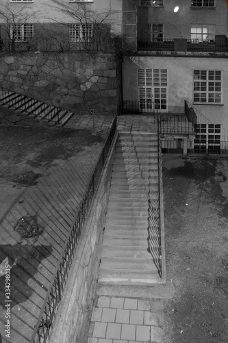 Depressing empty back yard in black and white, with shadows in electric light in evening