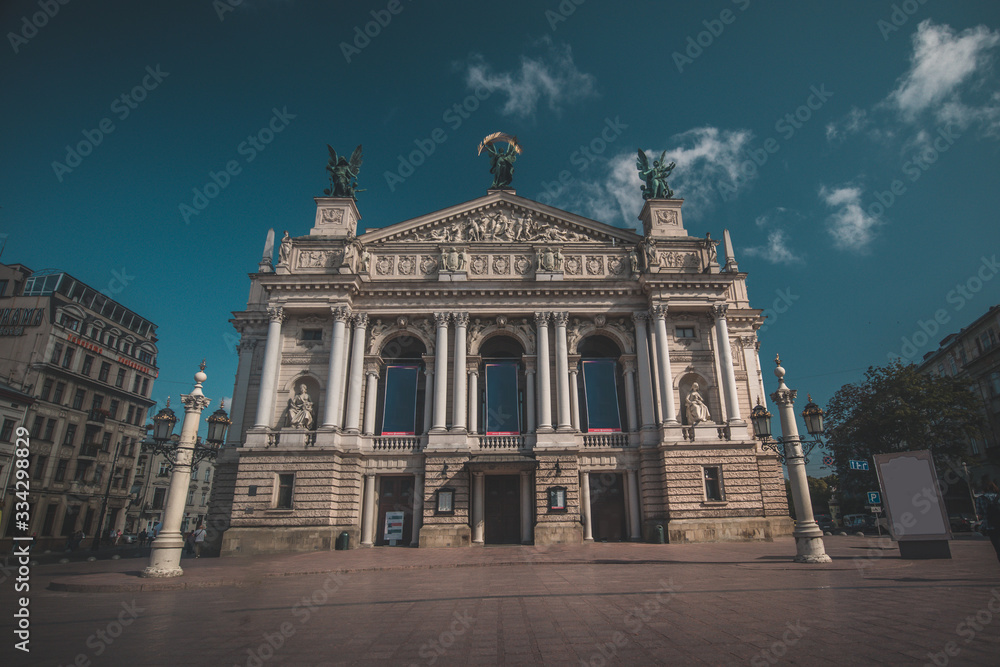 Fototapeta premium Beautiful opera building in Lviv, Ukraine on a hot summer day. Some clouds seen on blue skies.