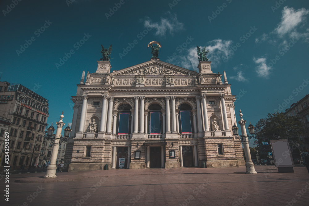 Beautiful opera building in Lviv, Ukraine on a hot summer day. Some clouds seen on blue skies.