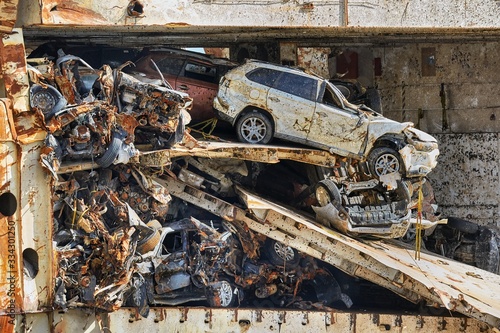 Fototapeta Wrecked car reamains in a big pile on a broken, sunk ship