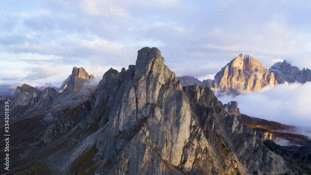 Aerial view of majestic dolomites mountains summit in the autumn sunset sun hidden behind the clouds. Golden hour.