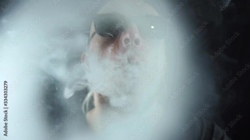 Man vaping big ring of steam and sends it to the camera with in slow motion Man vaping big ring of steam and sends it to the camera with in slow motion