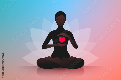 Woman sitting in lotus position and holding hands near her red heart