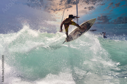 High energy surfer on a turbulent wave at sunset.