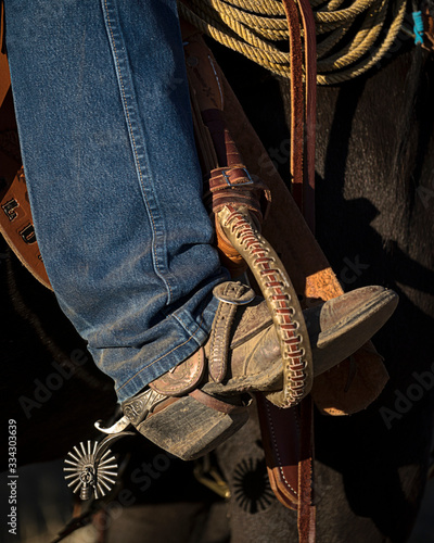 Gritty Rustic Cowboy Boot in Stirrups with Spurs Saddle and Horse