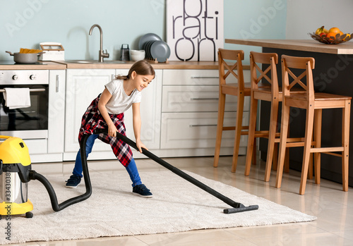 Little girl hoovering floor...