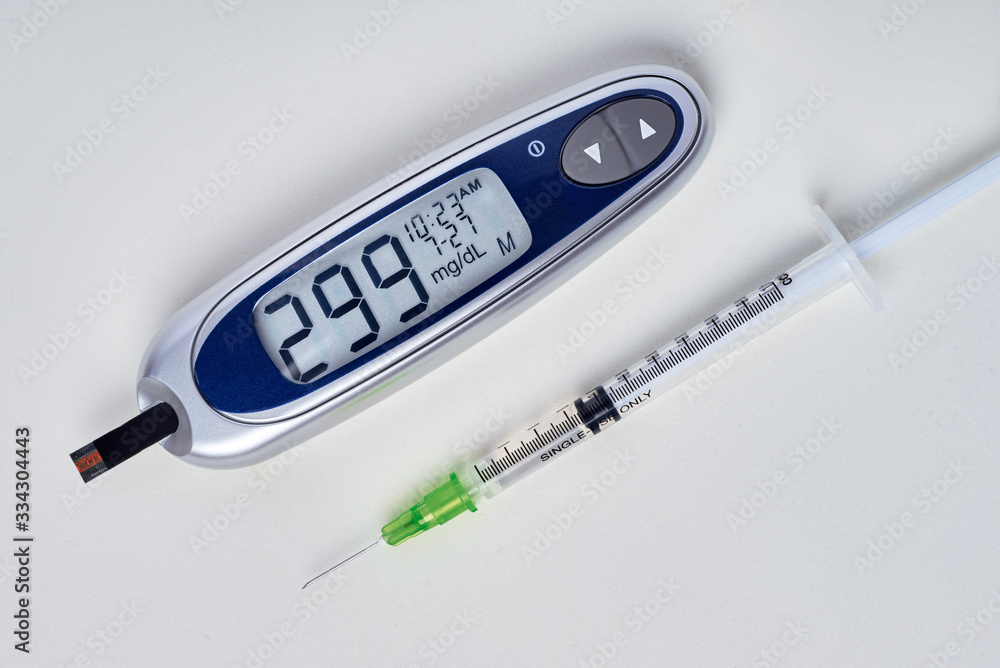 Obraz premium diabetes, glucometer with glucose measurement on screen and blood on test strip