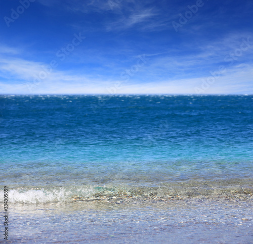 turquoise sea water surface under sunny sky with clouds