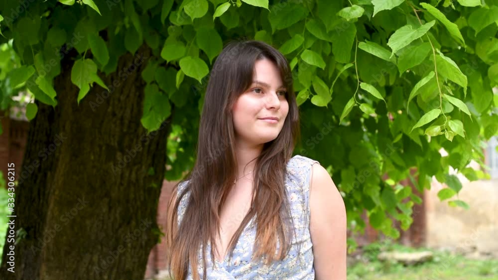 Attractive girl with long dark hair under tree branch Attractive girl with long dark hair under tree branch