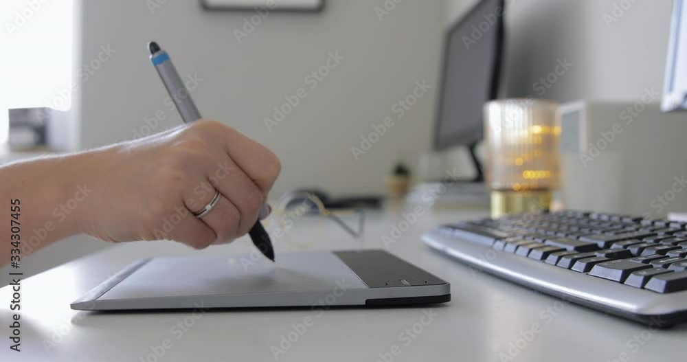 Close-up of hand drawing on a digital tablet with pencil. Professional retoucher working on graphic tablet. Graphic Designer working with interactive pen display Close-up of hand drawing on a digital tablet with pencil. Professional retoucher working on graphic tablet. Graphic Designer working with interactive pen display