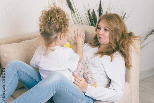 Caring mother amuses her daughter. Happy family concept