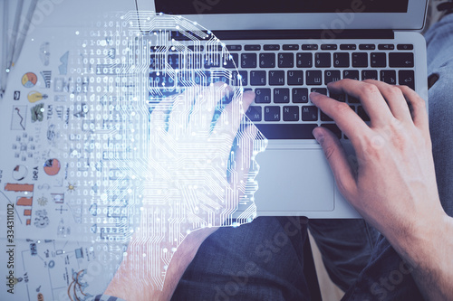 Double exposure of man's hands typing over computer keyboard and brain hologram drawing. Top view. Ai and data technology concept.