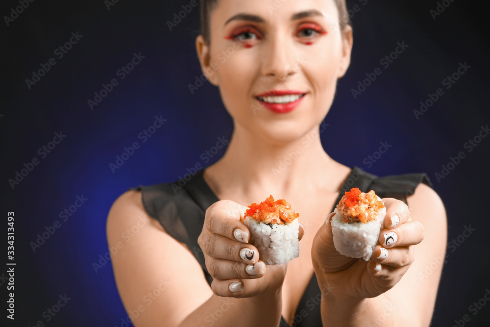 Beautiful woman with tasty sushi on dark background Beautiful woman with tasty sushi on dark background