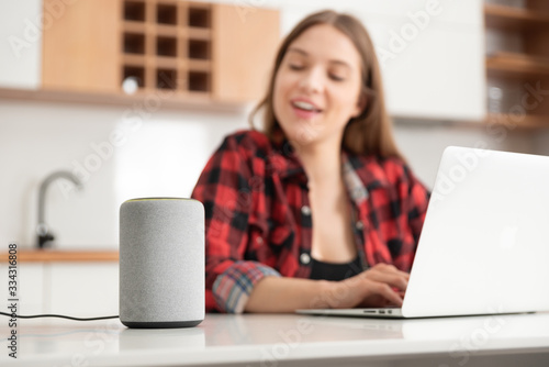 Woman talking to smart speaker. Smart home. photo