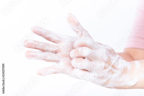 Closeup woman washing hands with soap on white background. Healthcare and disinfection concept. © Siam