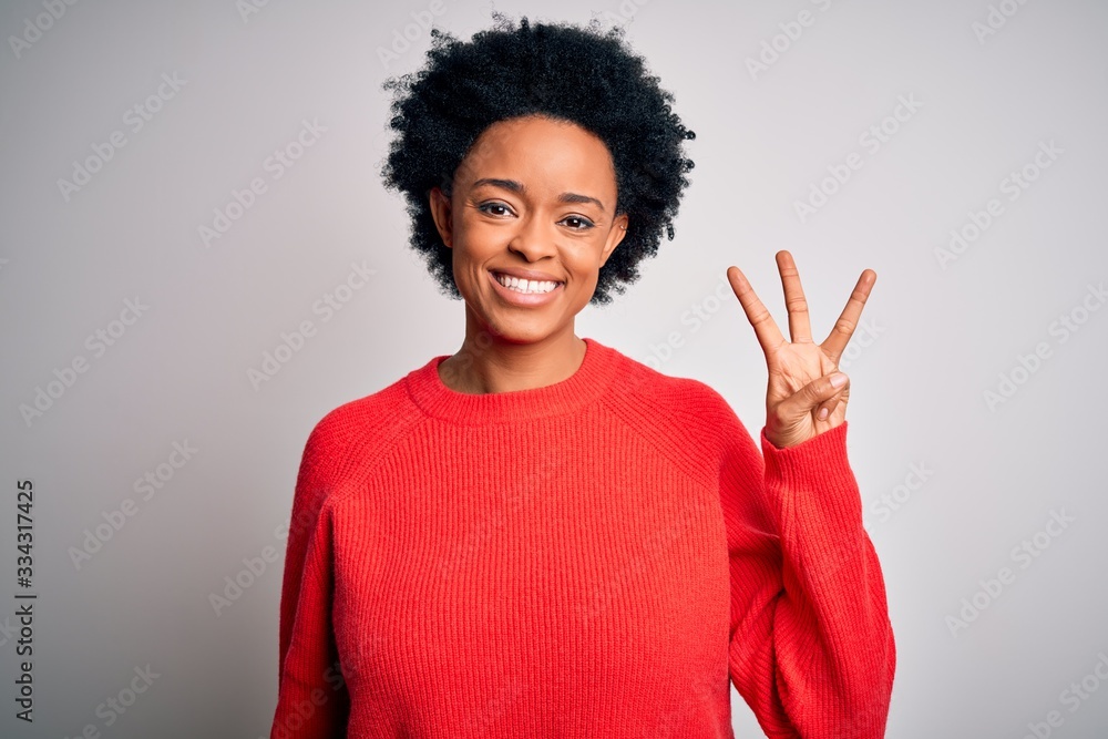 Young beautiful African American afro woman with curly hair wearing red casual sweater showing and pointing up with fingers number three while smiling confident and happy. Young beautiful African American afro woman with curly hair wearing red casual sweater showing and pointing up with fingers number three while smiling confident and happy.