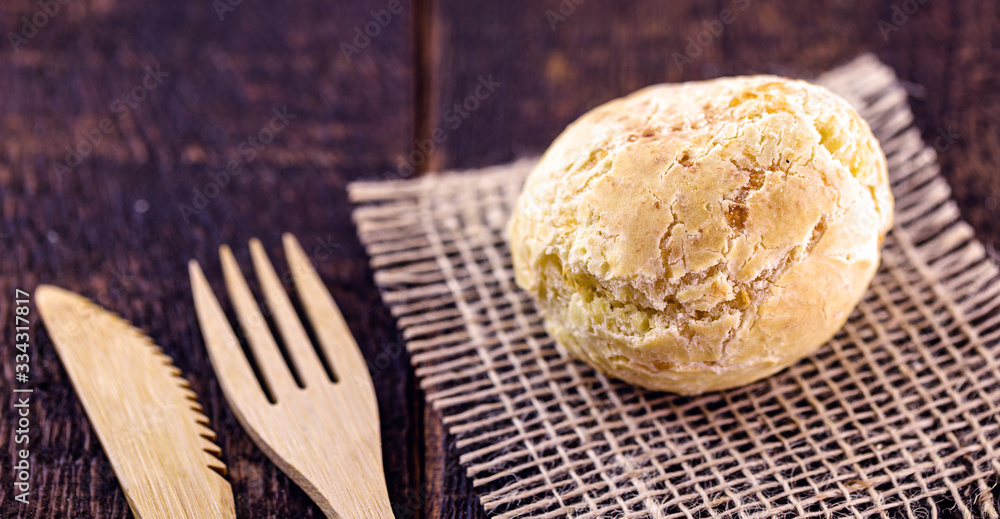Brazilian cheese bread, on rustic wooden background with environmentally friendly bamboo cutlery. Brazilian cheese bread, on rustic wooden background with environmentally friendly bamboo cutlery.