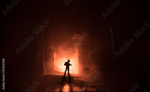 Empty street of burnt up city  flames on the ground and blasts with smoke in the distance. Apocalyptic view of city downtown as disaster film poster concept. Night scene. City destroyed by war.