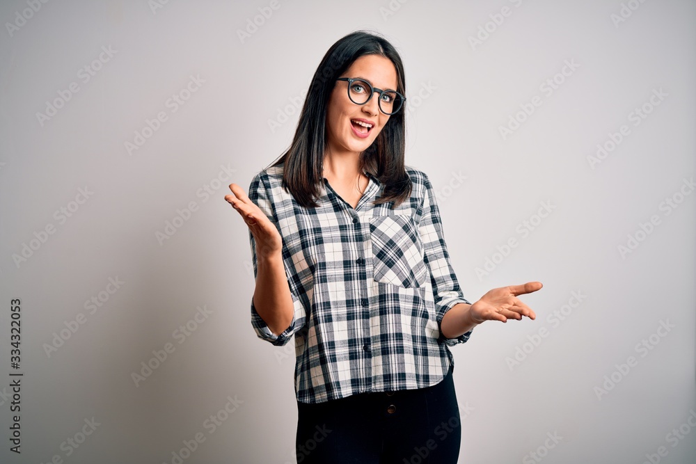 Young brunette woman with blue eyes wearing casual shirt and glasses over white background smiling cheerful with open arms as friendly welcome, positive and confident greetings Young brunette woman with blue eyes wearing casual shirt and glasses over white background smiling cheerful with open arms as friendly welcome, positive and confident greetings
