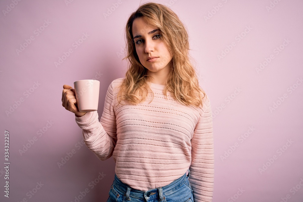 Young beautiful blonde woman drinking mug of coffee over isolated pink background with a confident expression on smart face thinking serious Young beautiful blonde woman drinking mug of coffee over isolated pink background with a confident expression on smart face thinking serious